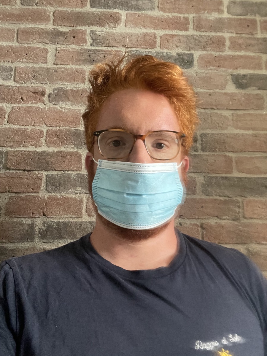 Yann wears a plain blue surgical mask.